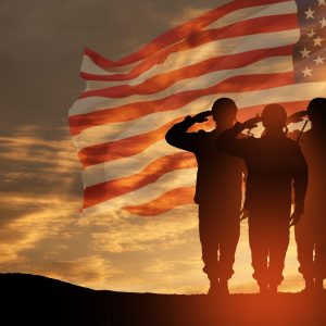 USA army soldiers saluting on a background of sunset or sunrise and USA flag. Greeting card for Veterans Day, Memorial Day, Independence Day. America celebration. 3D-rendering.