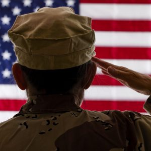 Female Soldier saluting the American Flag with shallow depth of field
