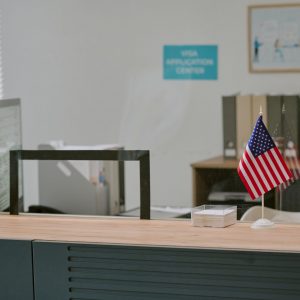 Interior of visa application center being depicted with tables, chairs, and American flag, highlighting organized and professional environment